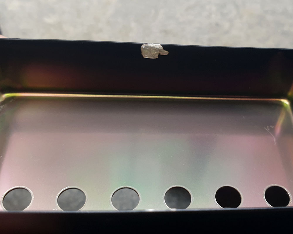 Black Humbucker Cover with base material exposed