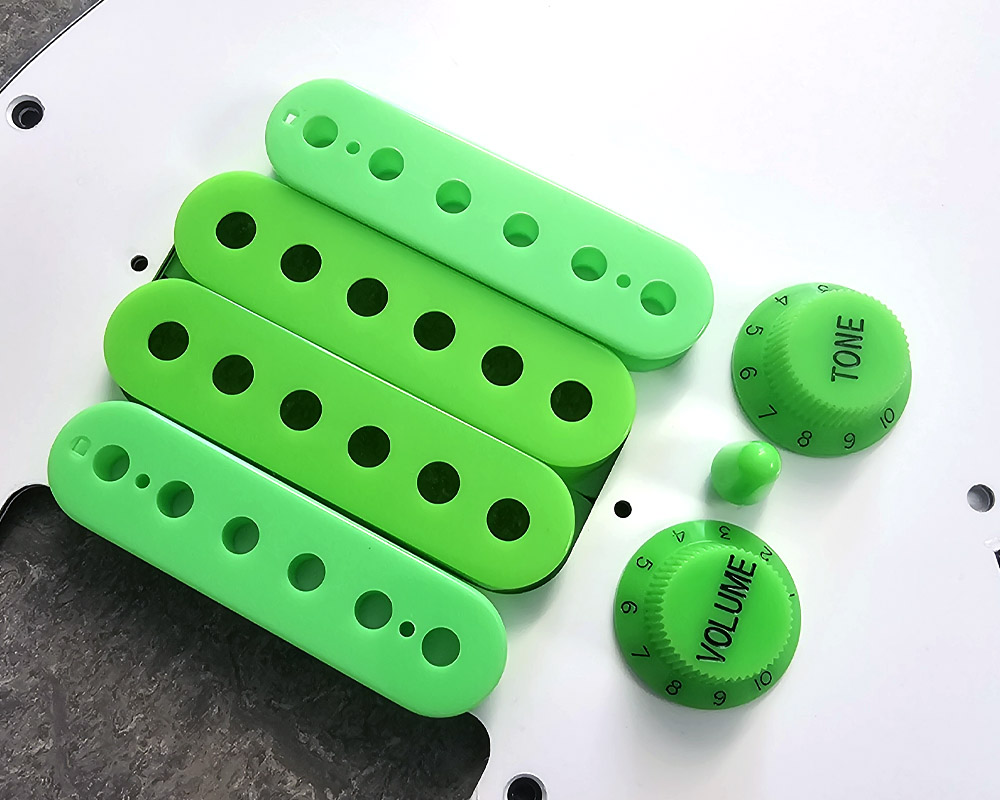 Parchment Humbucker Bobbins, Single Coil Cover, UFO knobs and TIp resting on a matching Stratocater pickguard