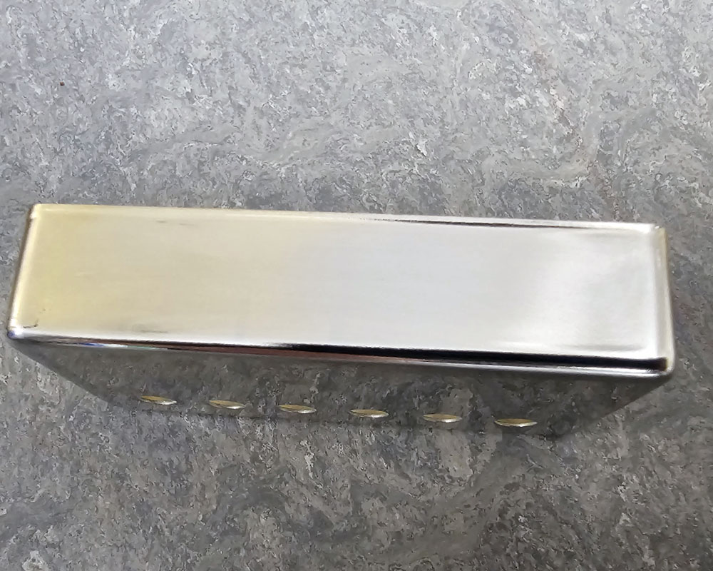 Gold humbucker cover after being polished